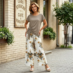 Colecția 2026: Tricou cu nod decorativ și pantaloni largi cu imprimeu floral. Croială lejeră care subțiază optic silueta!