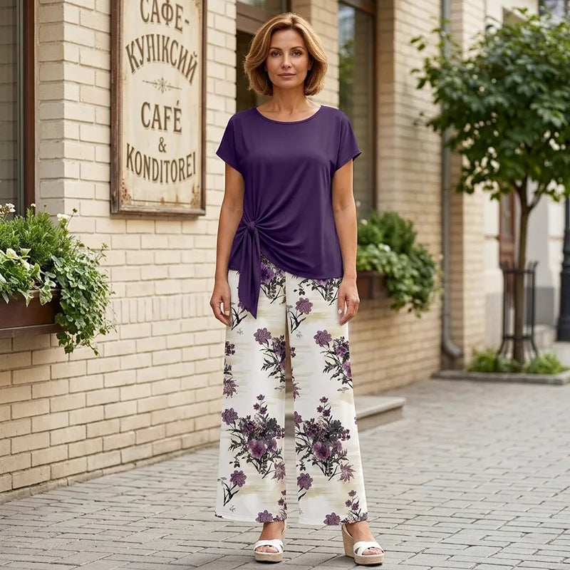 Colecția 2026: Tricou cu nod decorativ și pantaloni largi cu imprimeu floral. Croială lejeră care subțiază optic silueta!